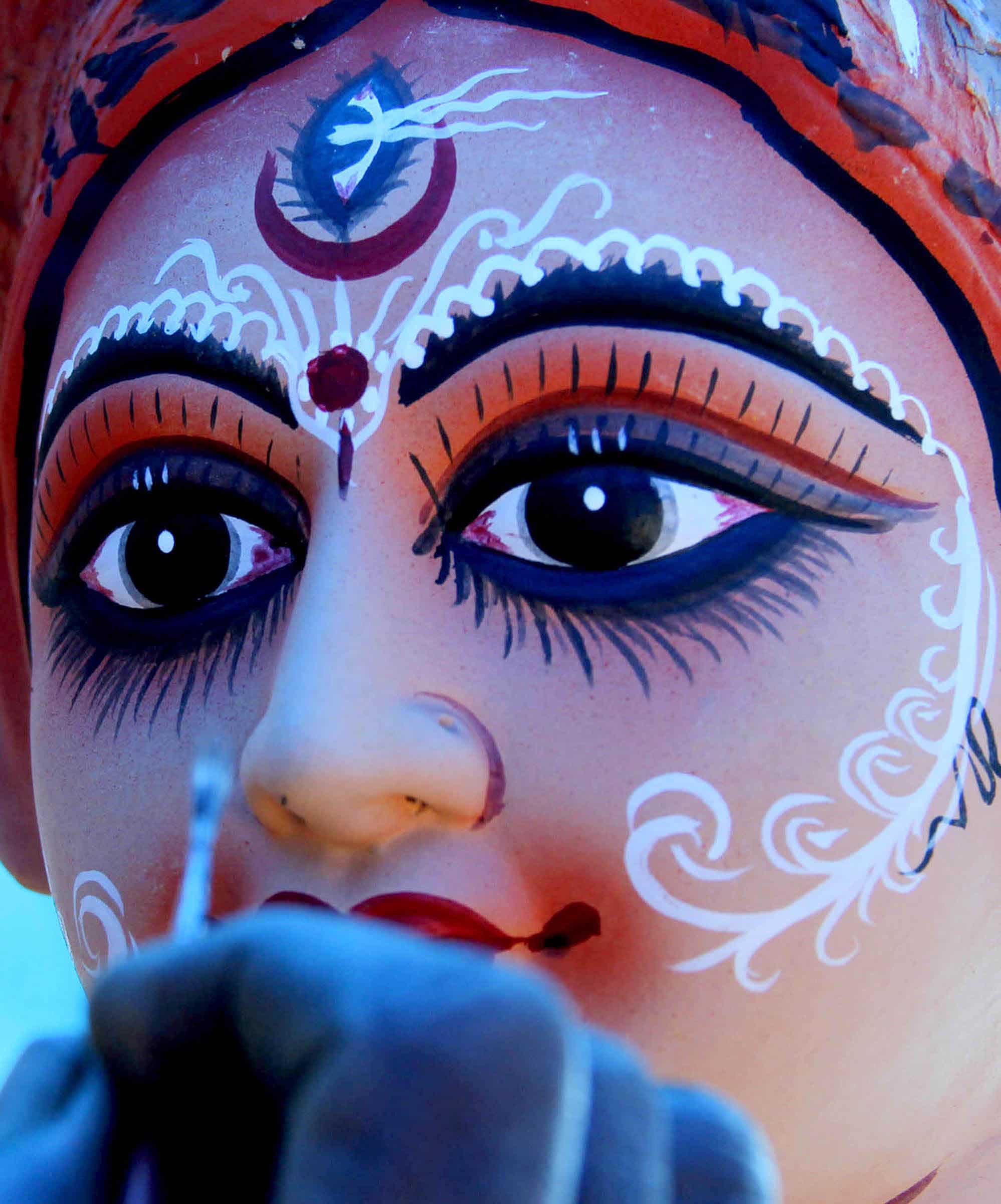 Artists give inishing touches to a clay idol of Goddess Durga at a workshop in Guwahati.