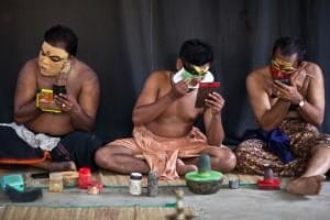 Photo: Kathakali performers apply makeup before an event in Kerala.