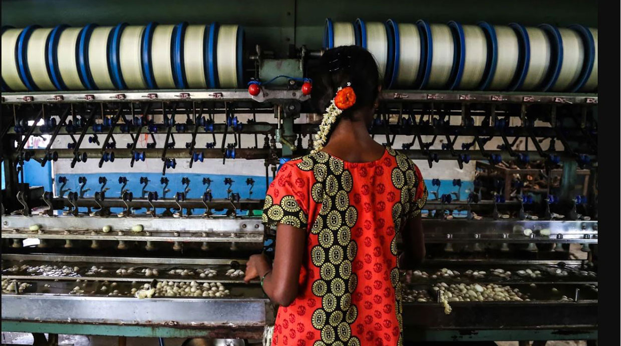 An underage laborer in the informal economy works in a silk factory in Sidlaghatta, India.