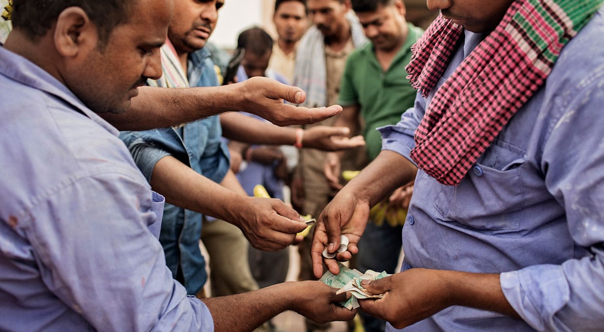 Migrants at an Al Arif construction company camp buy bananas from a vendor at the end of a work day, in Dubai, United Arab Emirates, in 2017.