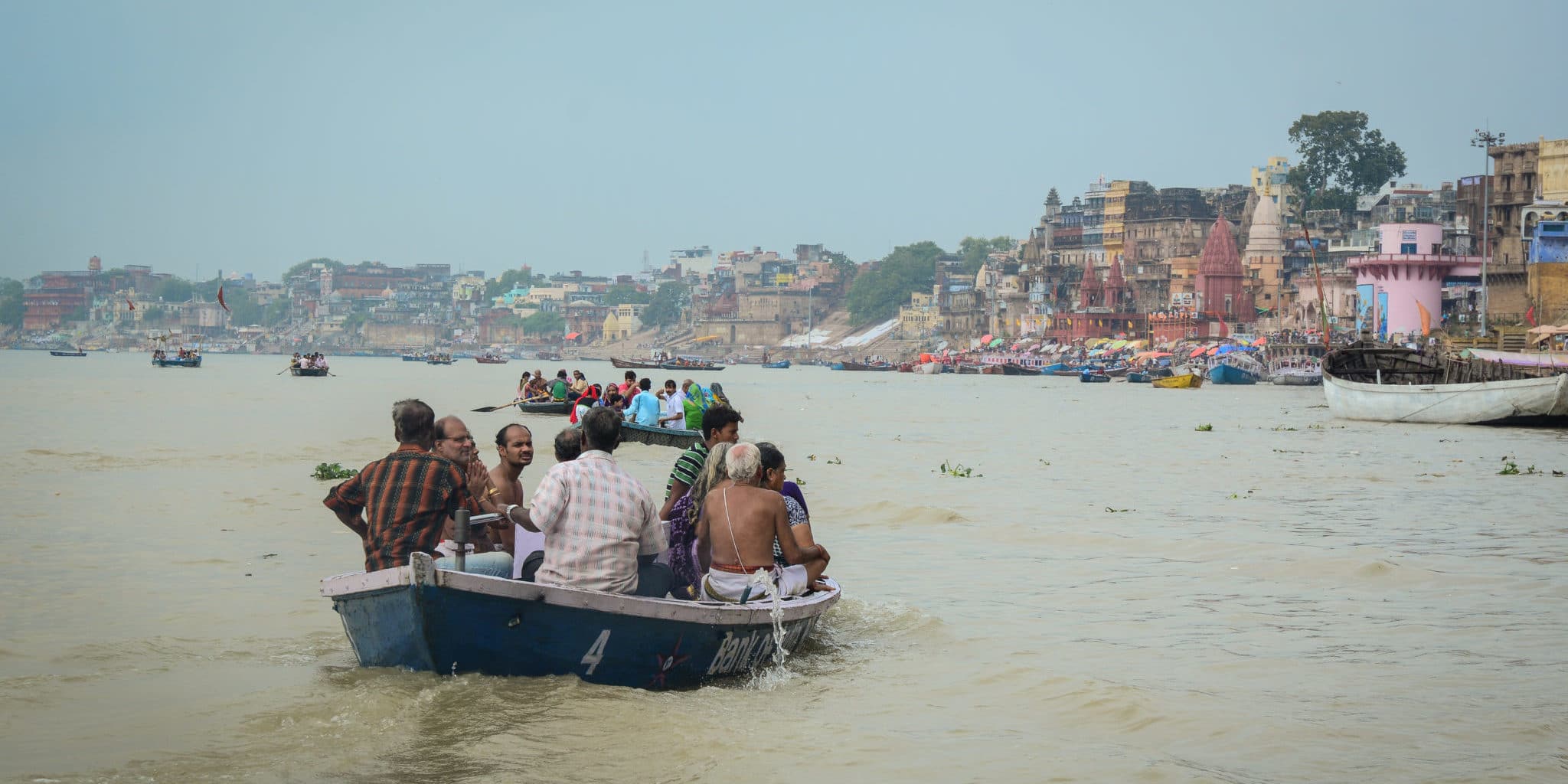 A wooden boat carrying people on the Ganga river in Varanasi.