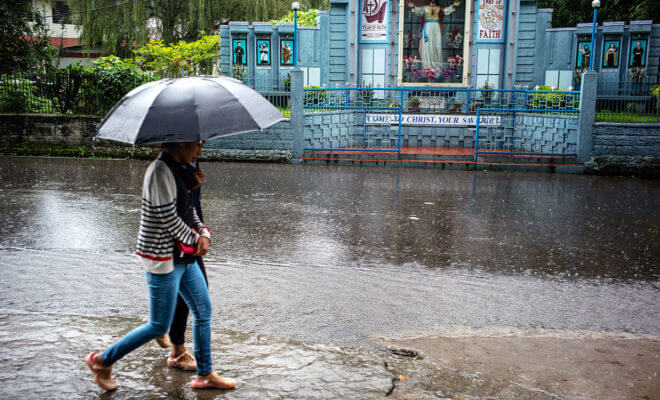 As climate change disrupts crop cycles and unleashes extreme weather on the Indian subcontinent, enthusiasts are amassing huge online followings. Two pedestrians walk near a shrine in Shillong, Meghalaya.