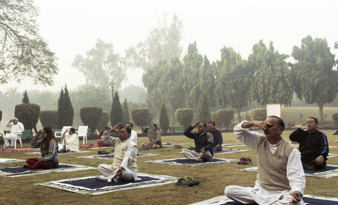 People perform a nostril breathing exercise while performing yoga at Lodhi Gardens in New Delhi. MUST CREDIT: