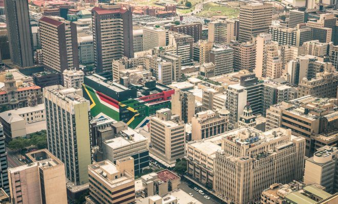 Aerial view of business district of Johannesburg with South African flag painted on structure walls.