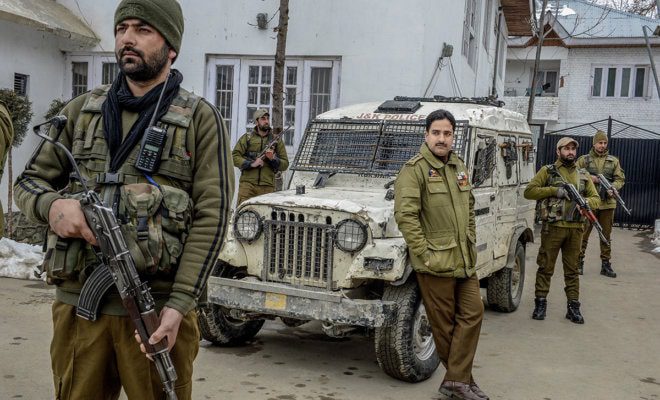 Officer Ashiq Tak, center, with his bodyguards outside his office in Shopian, India, in the state of Kashmir, Feb. 16, 2018.