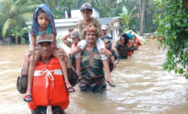 Indian defense personnel evacuating people from flood-hit areas of Kerala.