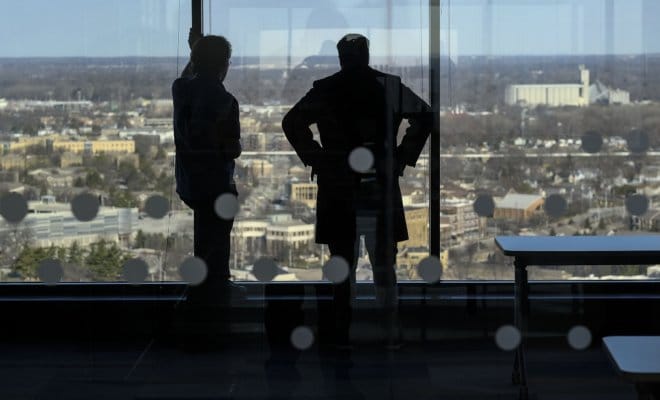 Workers chat while looking out over the Indianapolis skyline from the new Infosys office, on March 23, 2018.