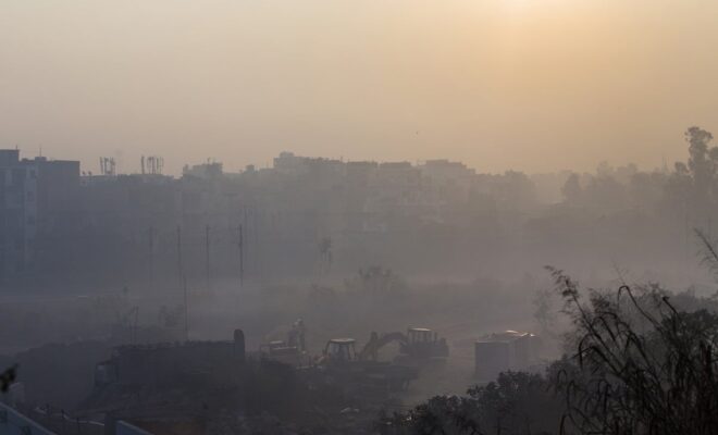 Construction equipment sits idle at a site shrouded in smog in Delhi, India.