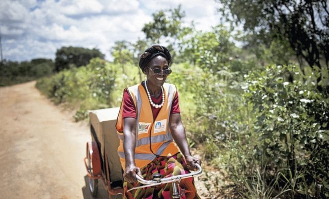 A image provided by Toby Madden/Transaid shows Josephine Mupeta, a volunteer health worker on a bicycle ambulance carrying supplies for identifying and treating malaria, in Serenje, Zambia. A multipronged program to combat malaria in remote villages has cut child mortality rates from the disease by 96 percent. Toby Madden/Transaid via The New York Times.